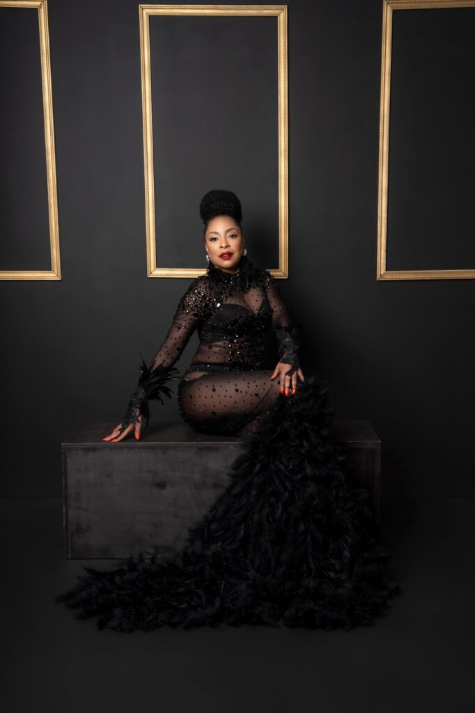 Feathered long black jeweled dress of African American women in the studio